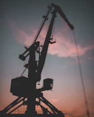 A security camera overlooking a heavy-duty crane in operation at dusk