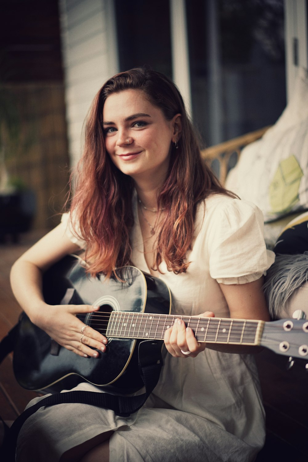 woman in white shirt holding acoustic guitar