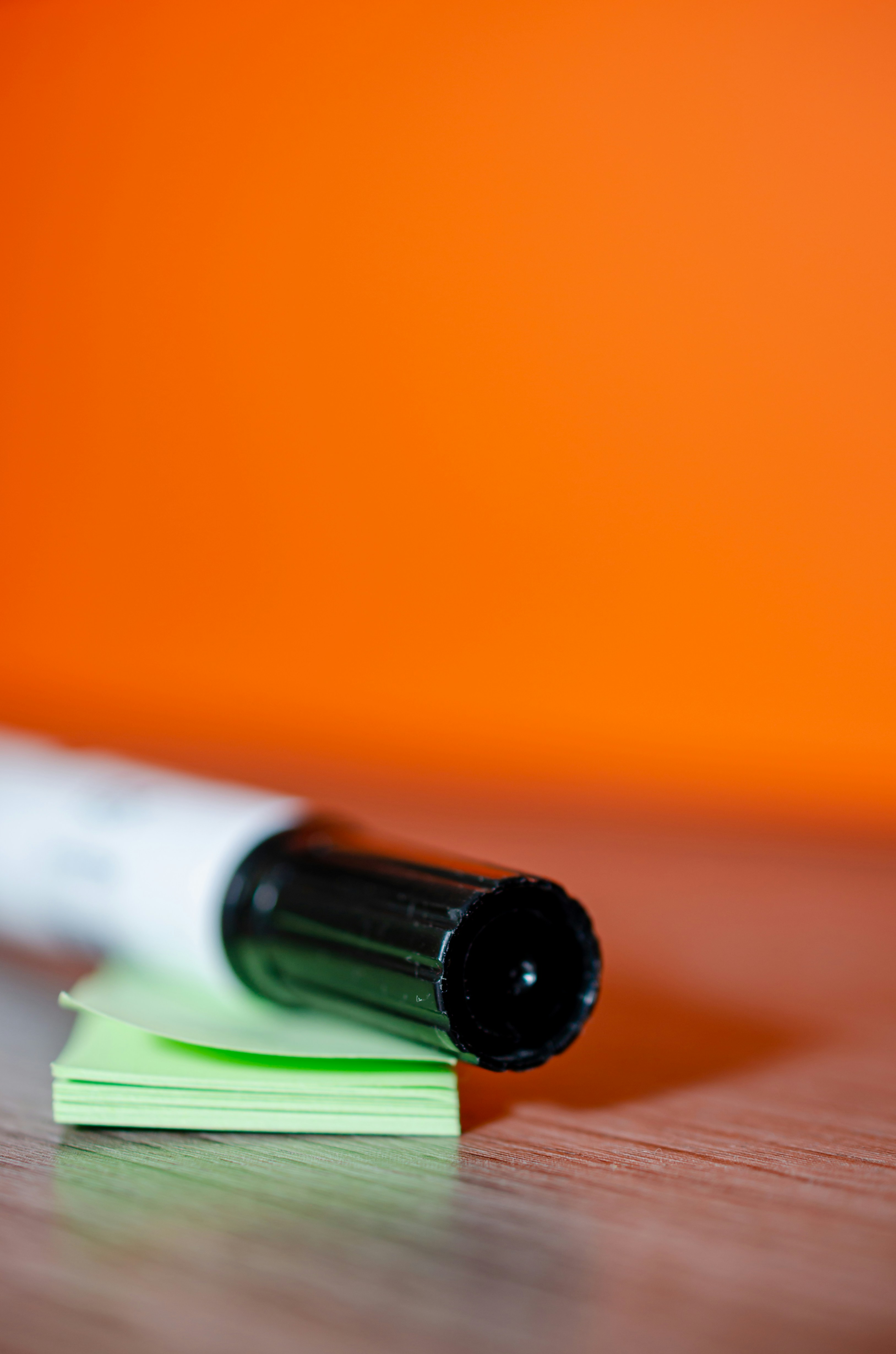 white and green pen on orange surface