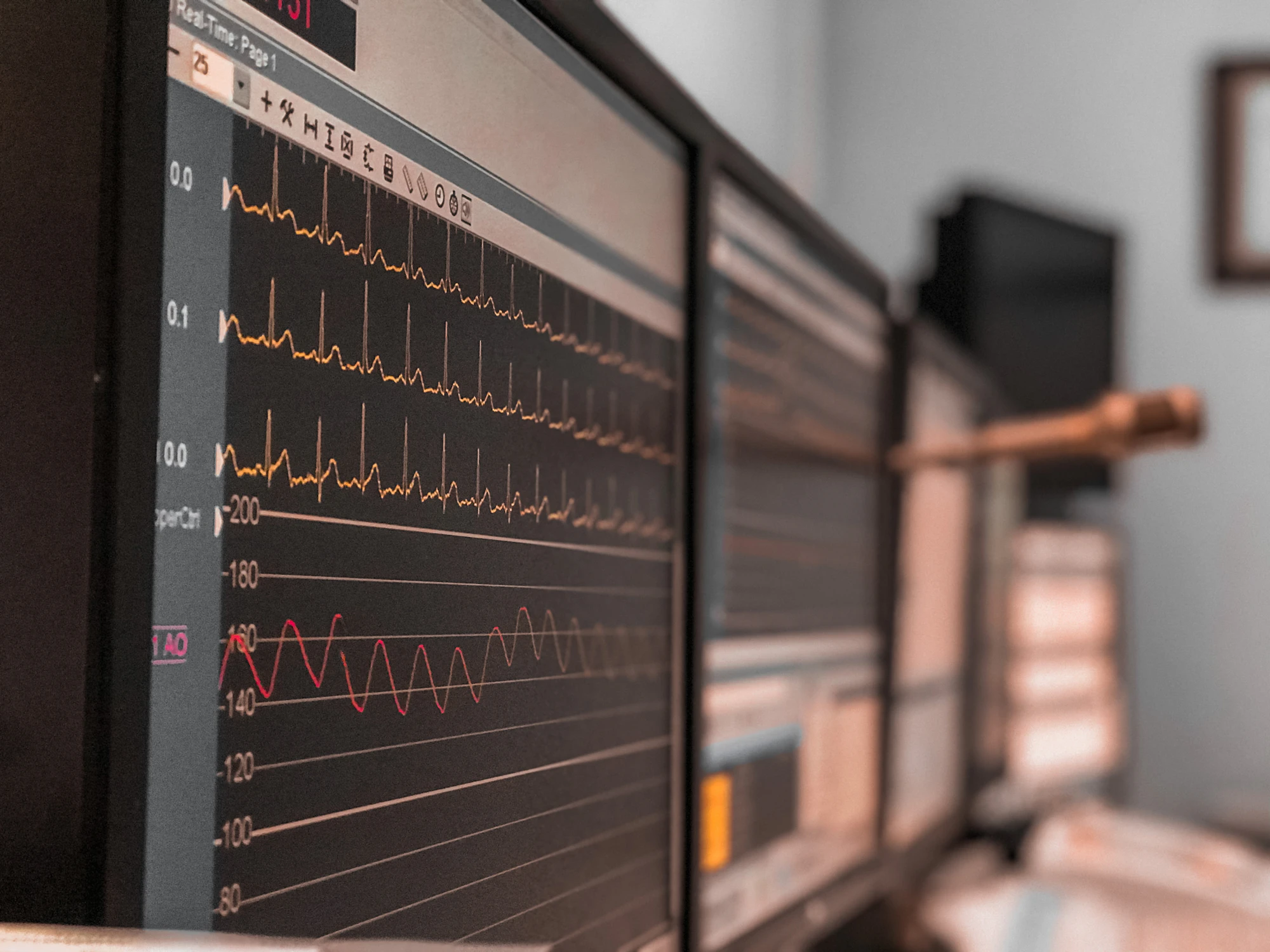 Advanced medical monitoring equipment in dark ICU room, glowing screens