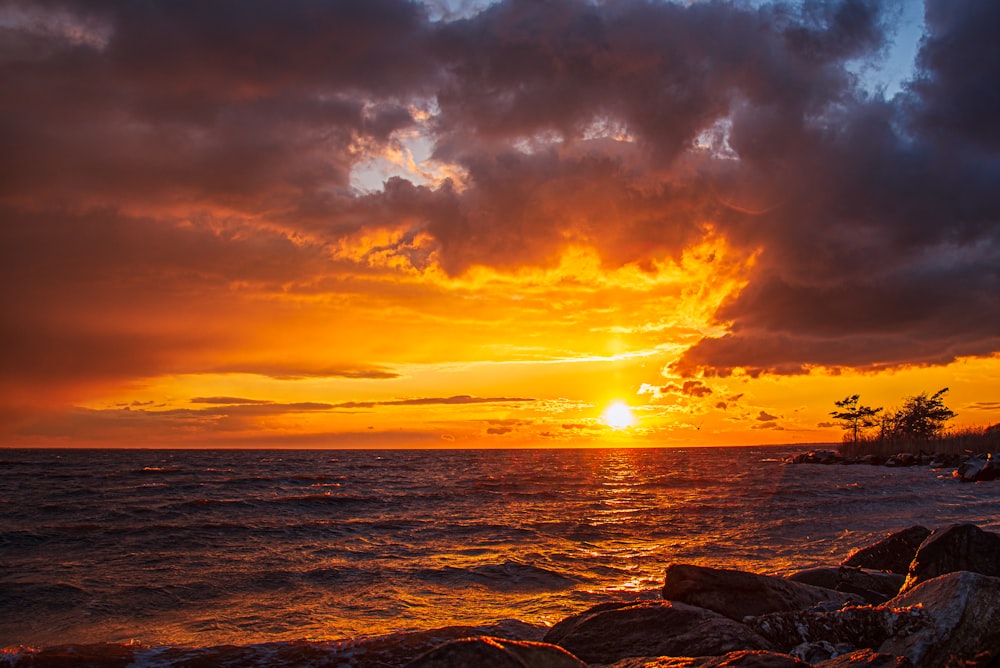 body of water under cloudy sky during sunset