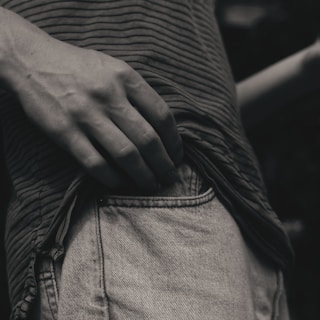person in black and white striped long sleeve shirt and gray denim jeans
