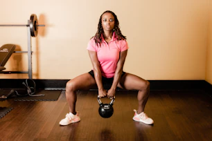 a woman holding a kettle in a gym