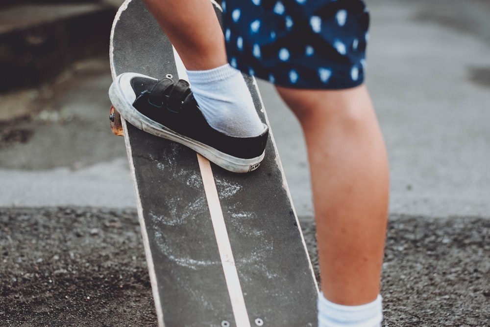 person in blue and white polka dot shorts and black and white nike sneakers