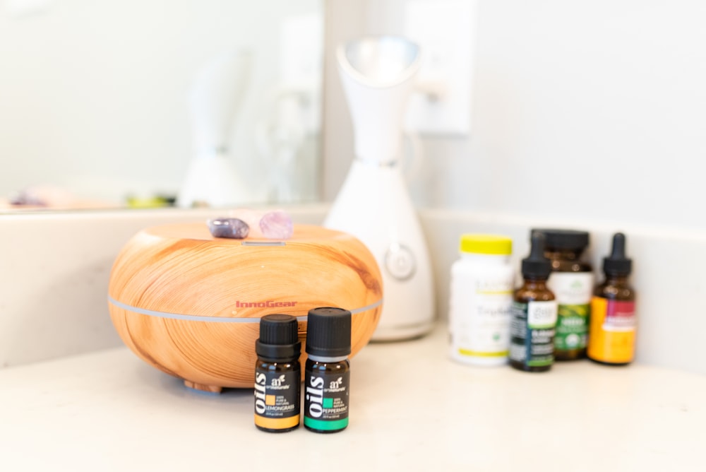 bottles of essential oils sit on a counter in front of a mirror