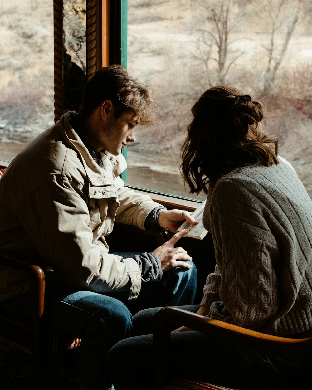 man and woman sitting on bench