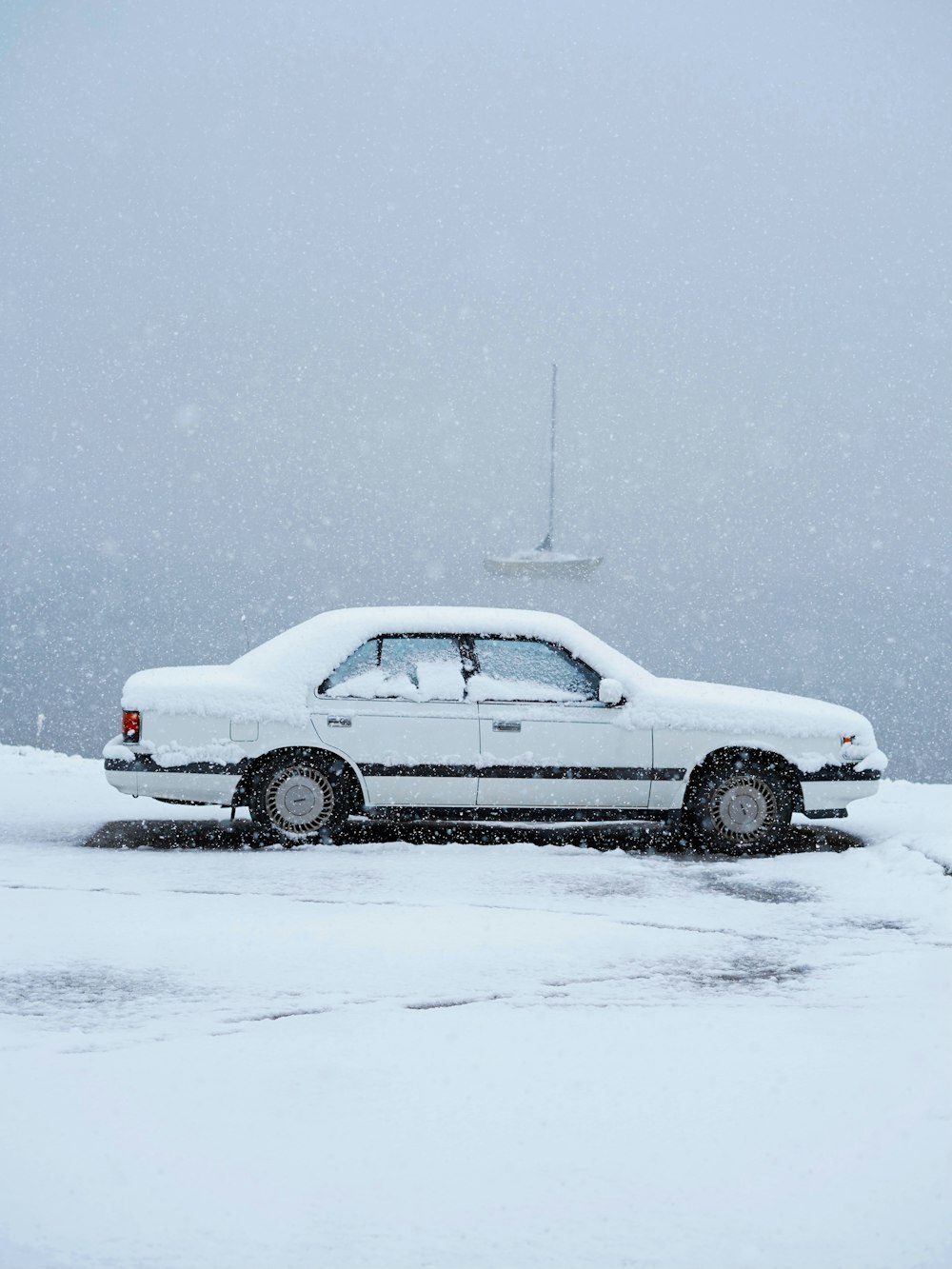 white sedan on snow covered ground