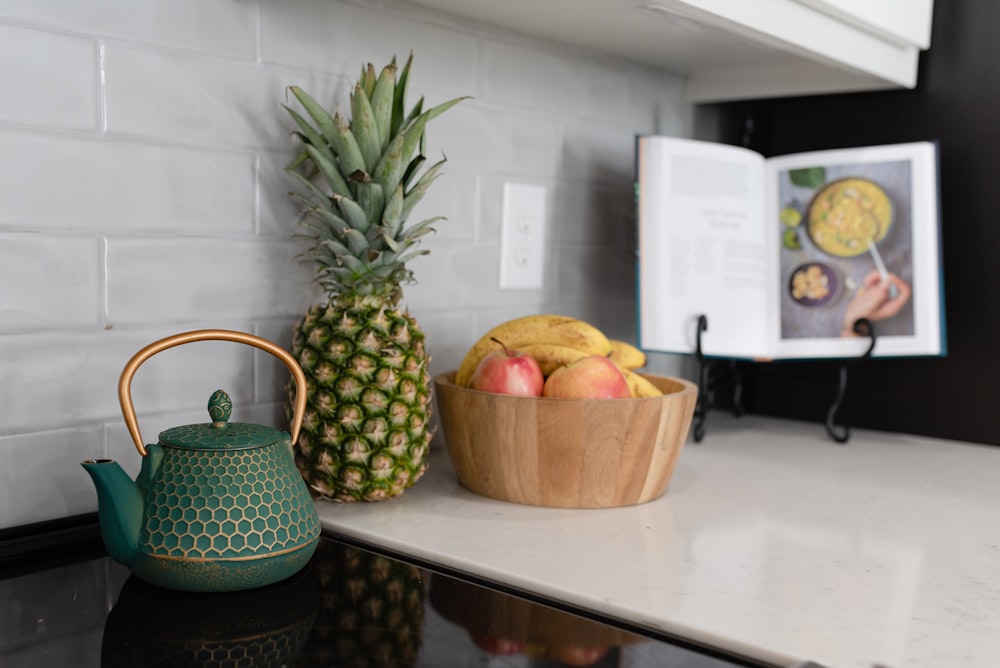 a pineapple and a bowl of fruit on a counter