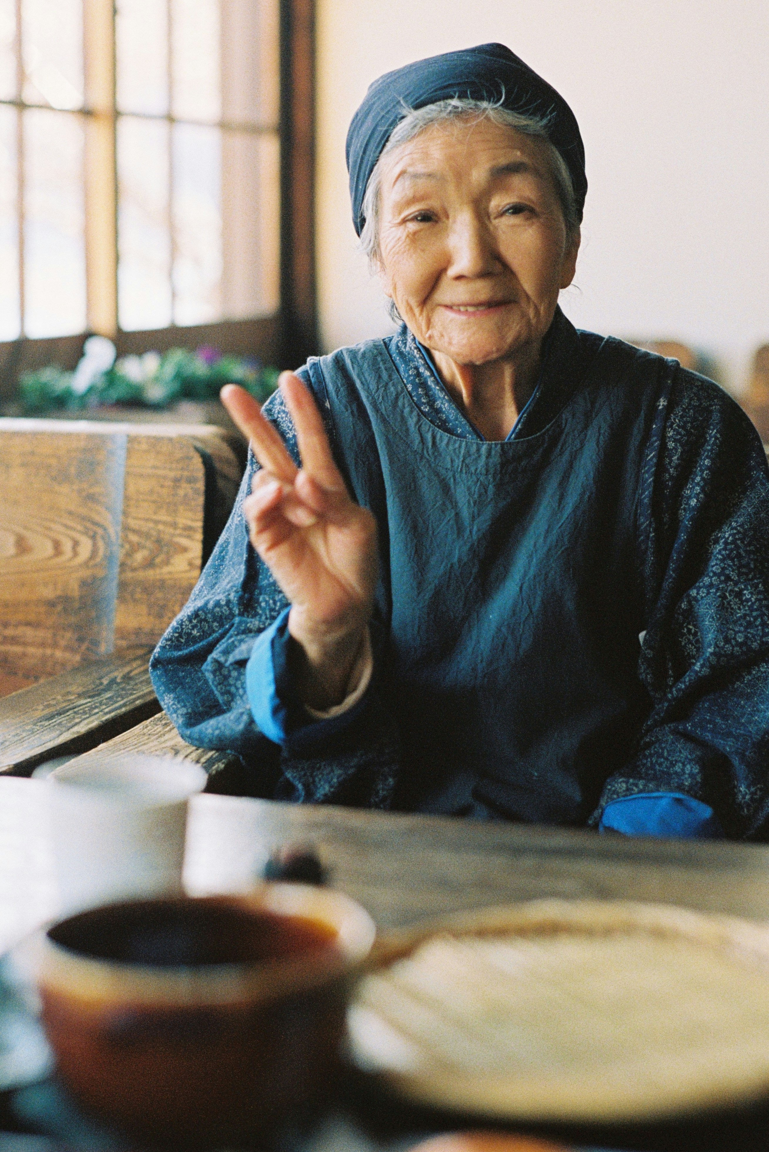 woman in blue sweater sitting by the table