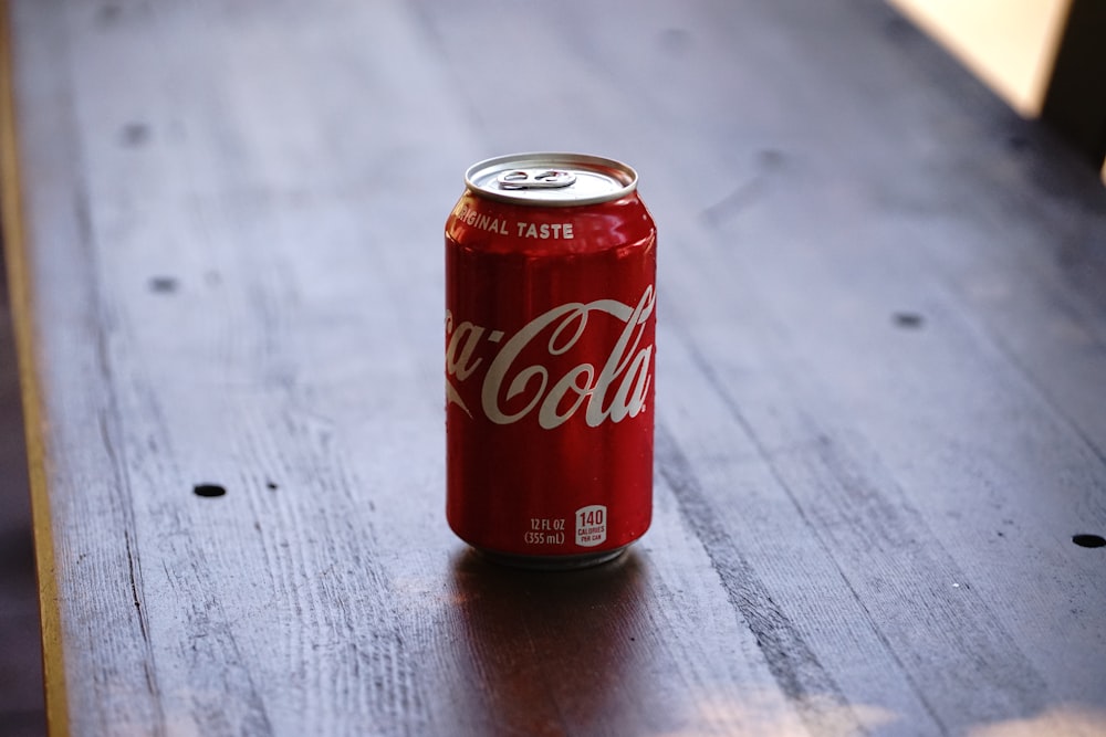 lata de coca-cola na mesa de madeira cinza