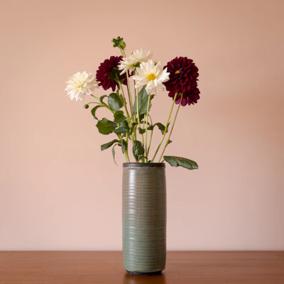 Luxurious floral arrangement featuring deep red and cream flowers in a modern vase