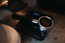 A barista carefully measuring coffee grounds with a vintage scale in a cozy café.