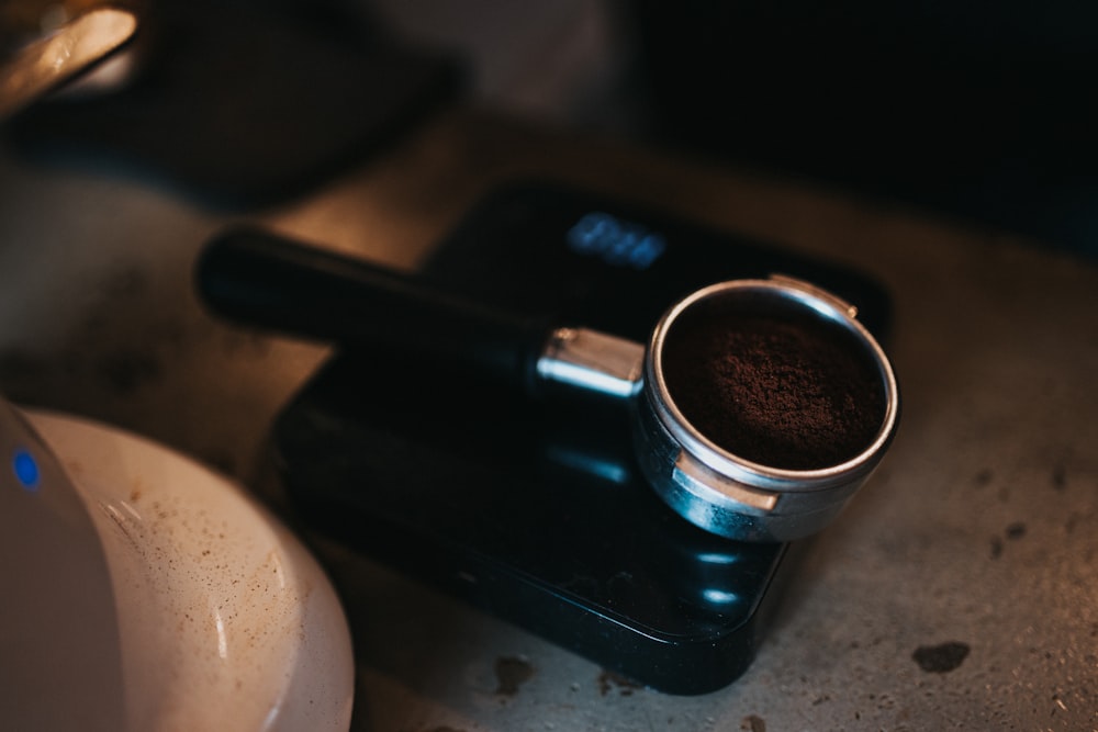 black and silver coffee mug on black saucer