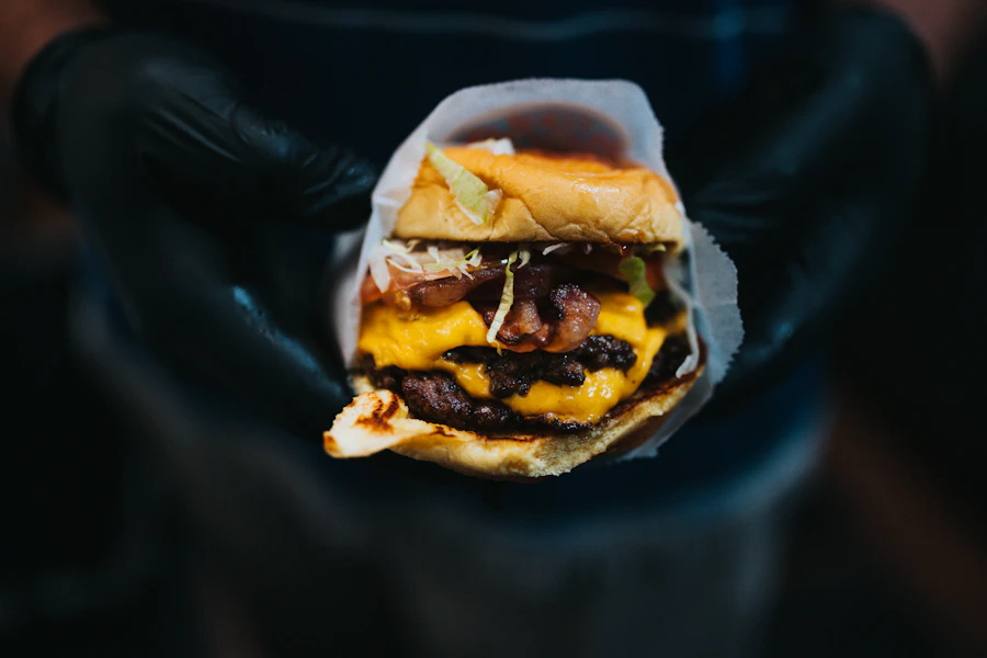 Smashburger com queijo derretido e alface, montado no pão brioche