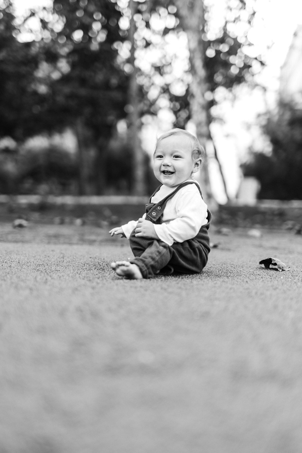 地面に座っている子供のグレースケール写真