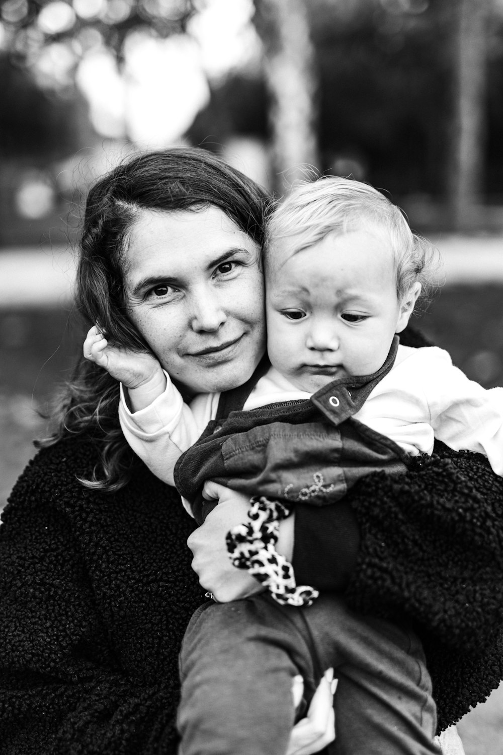 woman in black long sleeve shirt carrying baby in white shirt