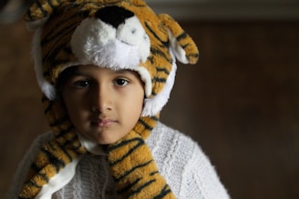 Close-up of a smiling child wearing a Cute Mudy playful hat with rounded ears.