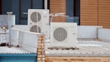 white and gray box fan on brown wooden table
