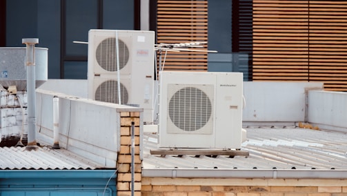 white and gray box fan on brown wooden table