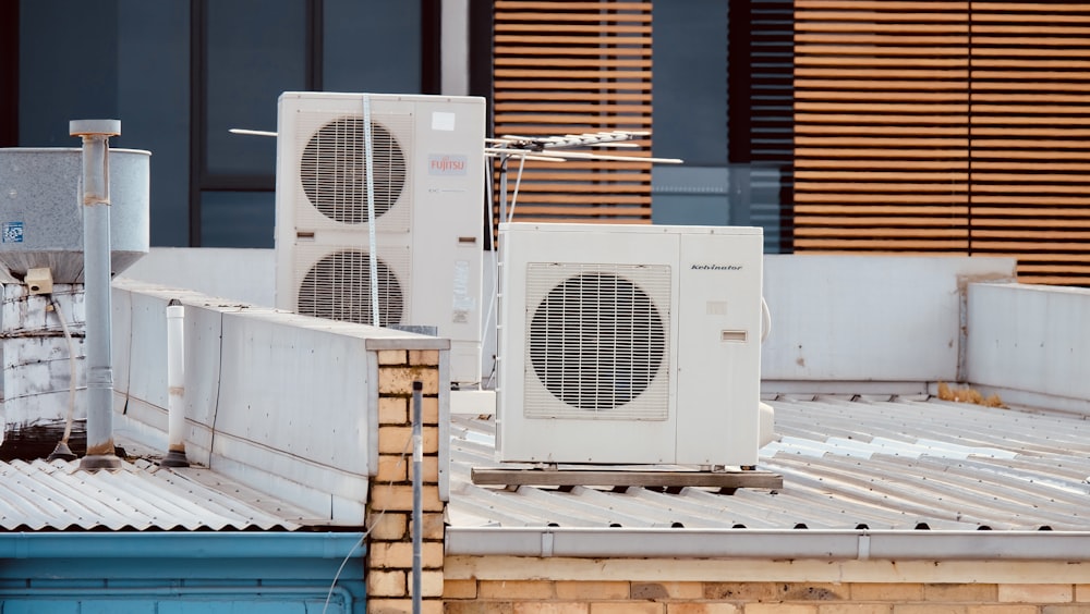 Ventilador de caja blanco y gris sobre mesa de madera marrón