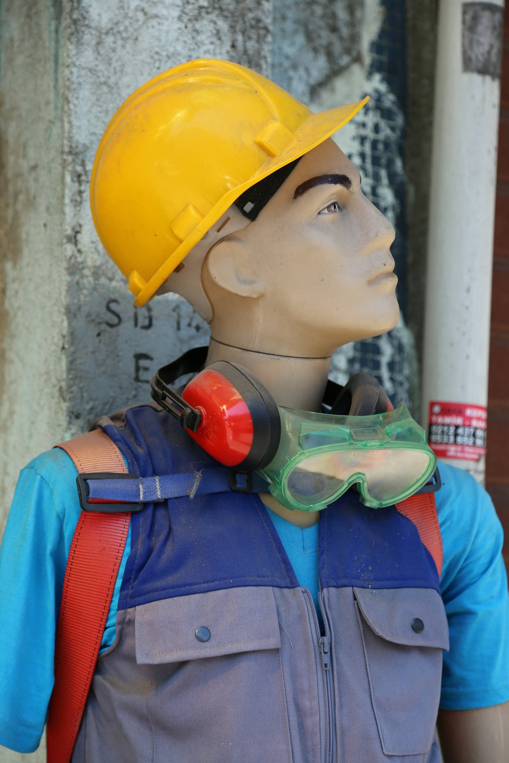 boy in blue and orange jacket wearing yellow hard hat