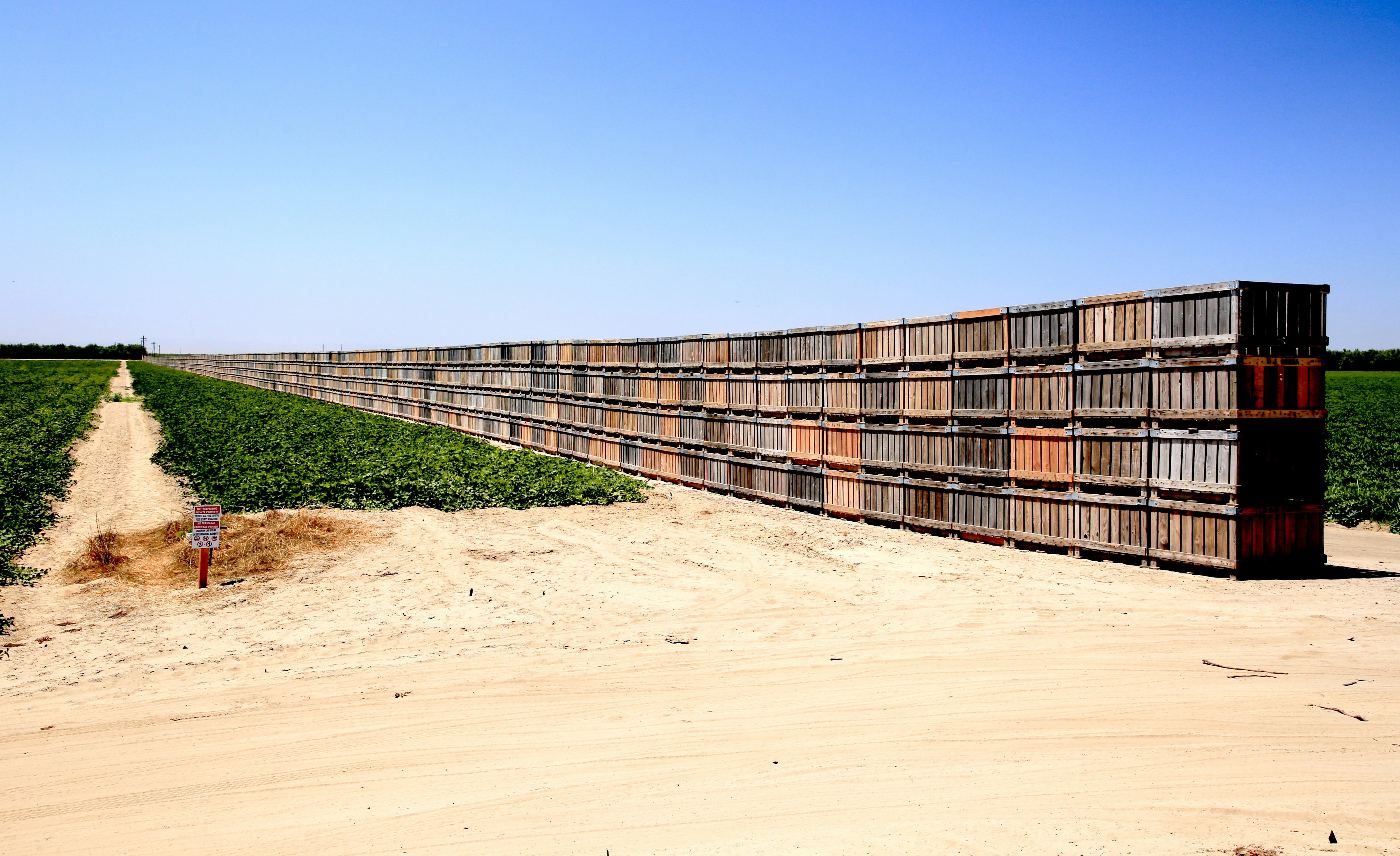 brown wooden fence on brown sand during daytime