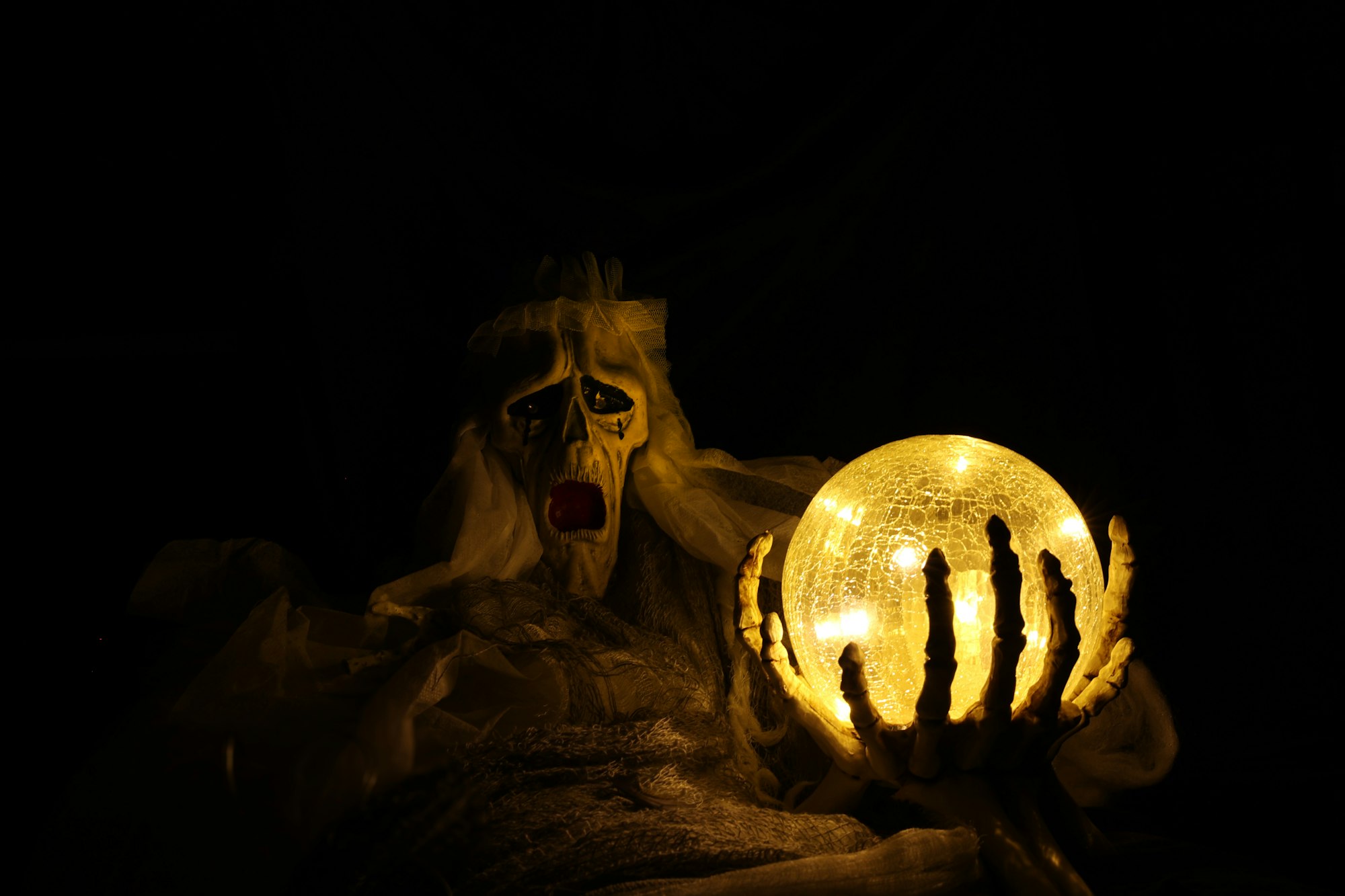 a skeletal figure holding a brightly light orb