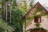 brown and white wooden house near green trees during daytime