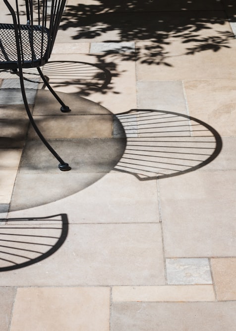 Natural stone patio pavers dappled with the shadows of overhanging tree branches
