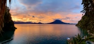 Sunset view over Lago de Coatepeque with a restaurant terrace in the foreground.