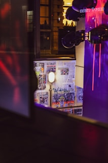 Dimly lit cafe interior with neon green ghost illustrations glowing on deep purple walls