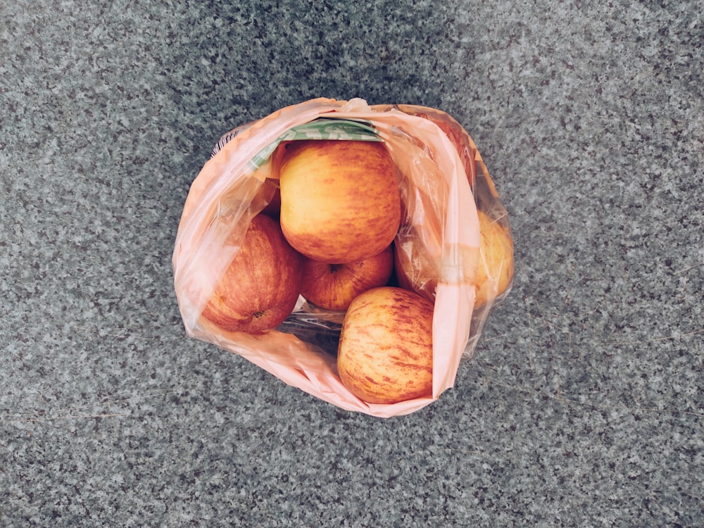 brown round fruits in brown plastic bag