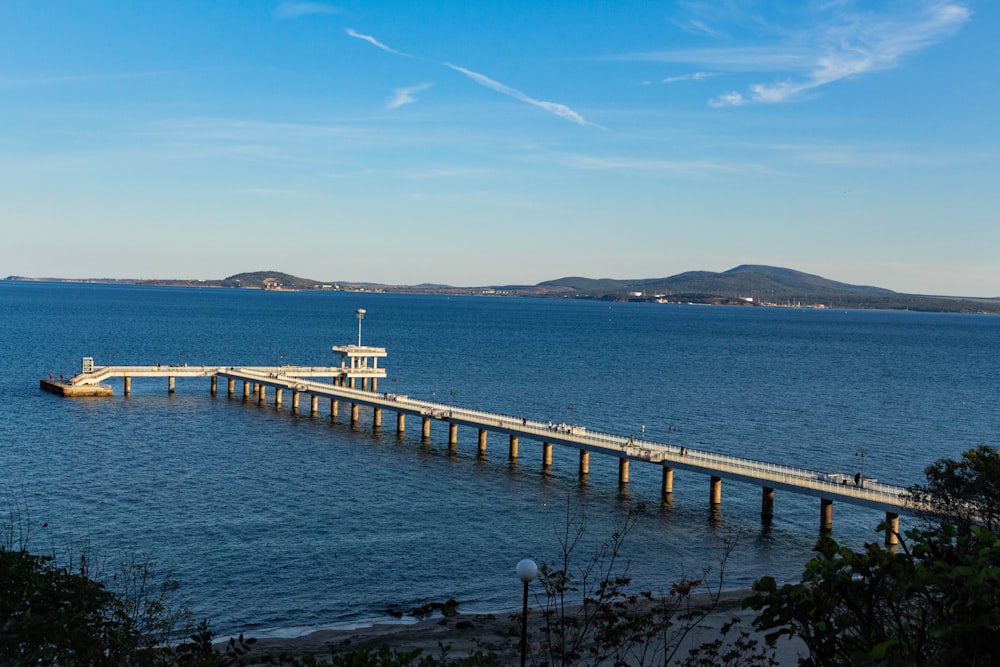 white and brown wooden dock on sea under blue sky during daytime