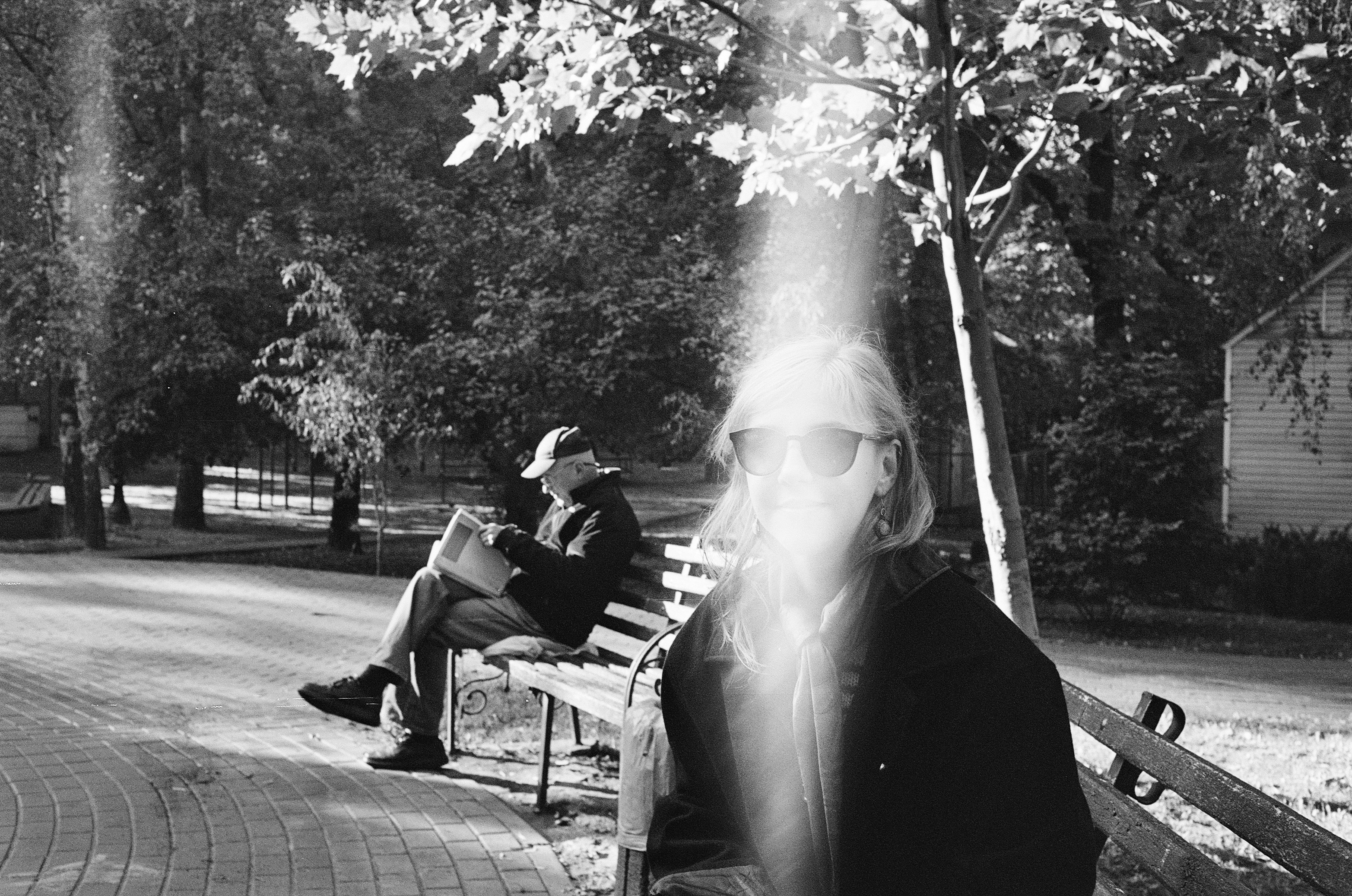 grayscale photo of woman sitting on bench