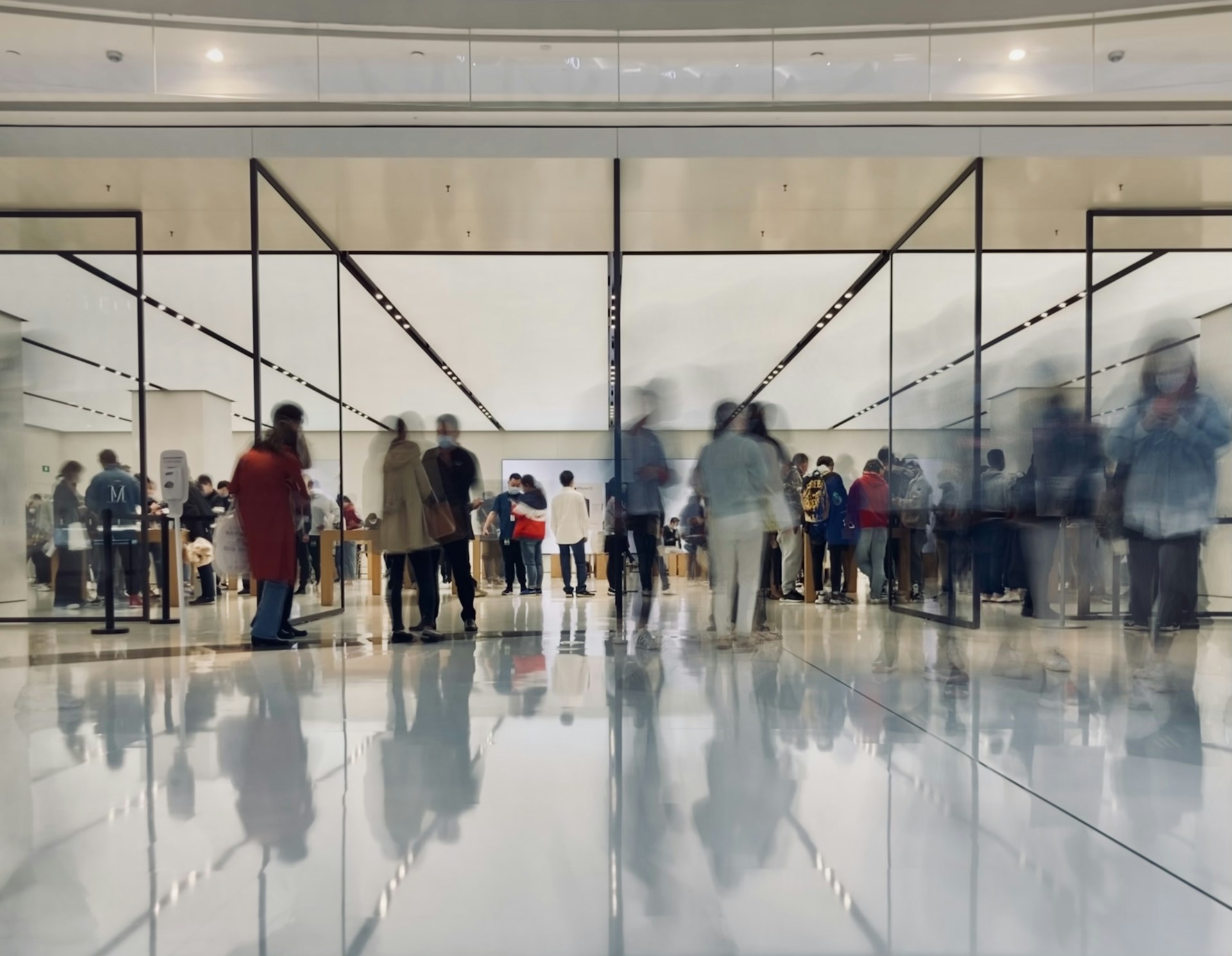 A diverse group of people smiling and enjoying shopping together in a bright modern store.