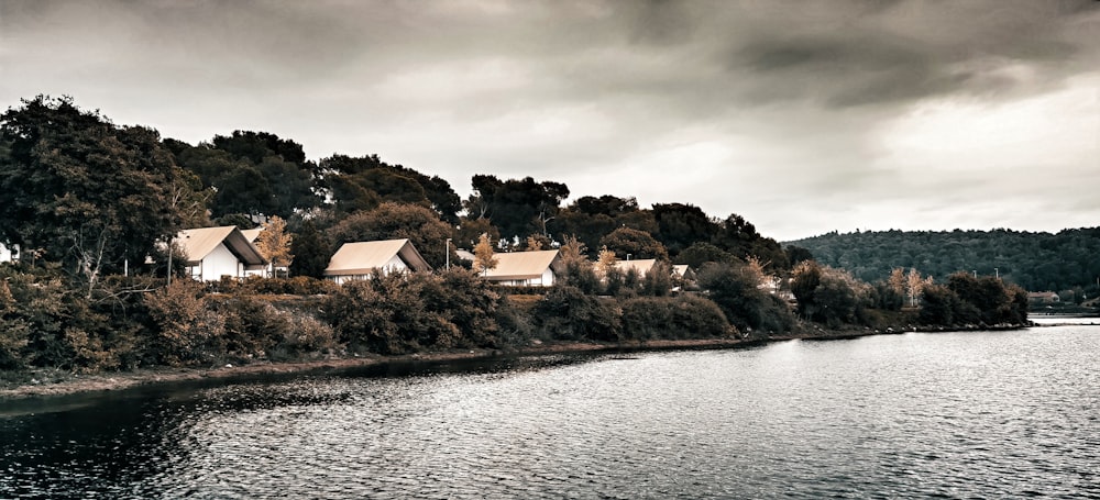 Casa marrón y blanca cerca del cuerpo de agua bajo nubes grises