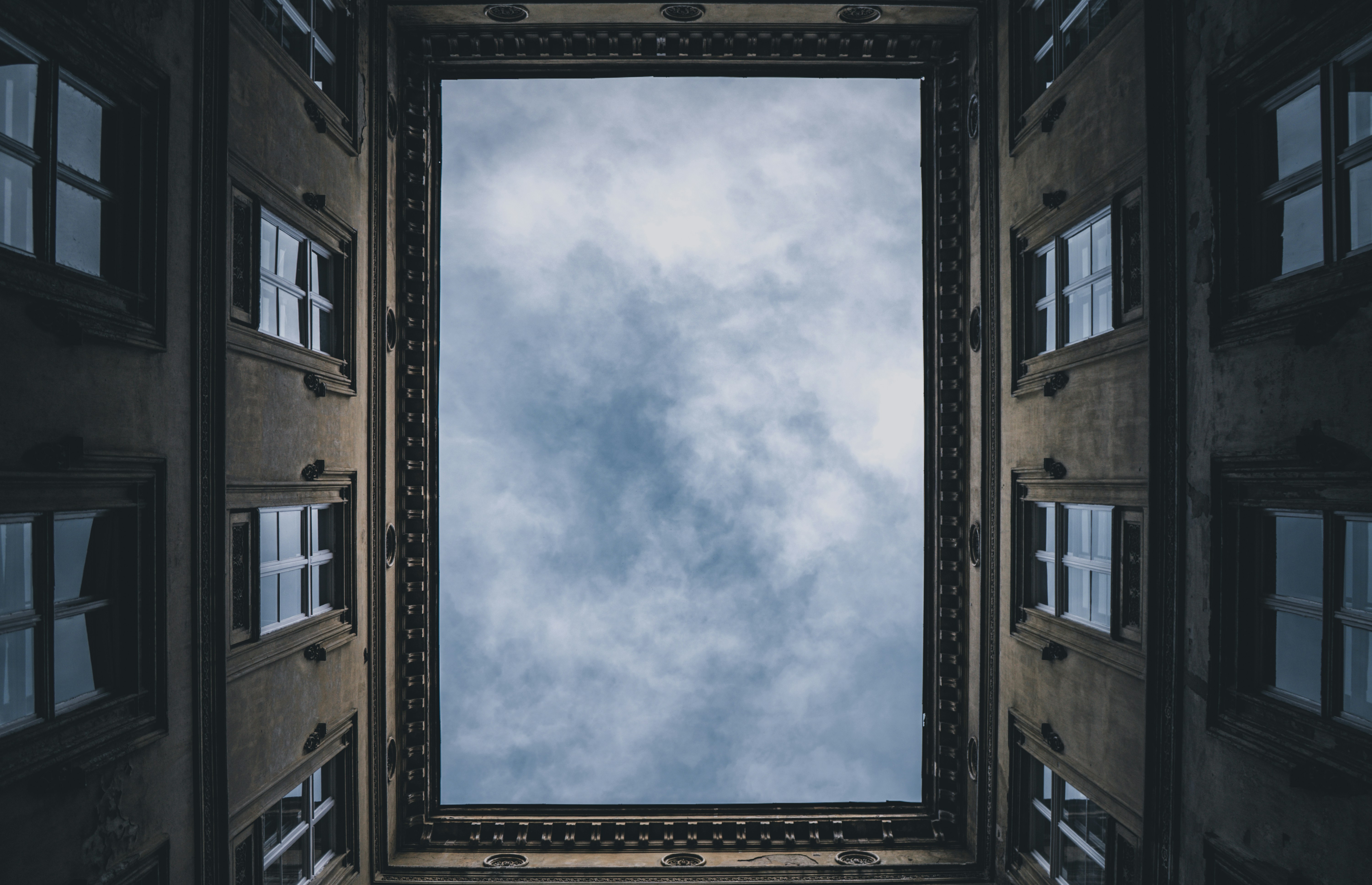 Looking up at the sky, framed by building walls.