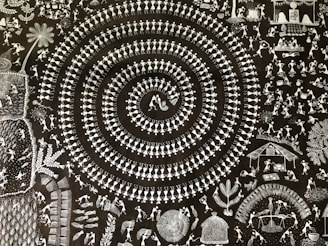 A intricate artwork featuring a concentric spiral made up of small, stylized human figures in traditional dance poses. Surrounding the spiral are various scenes depicting daily life, including people working in fields, celebrating, and dancing. The design is highly detailed, with numerous small figures and objects filling the space.