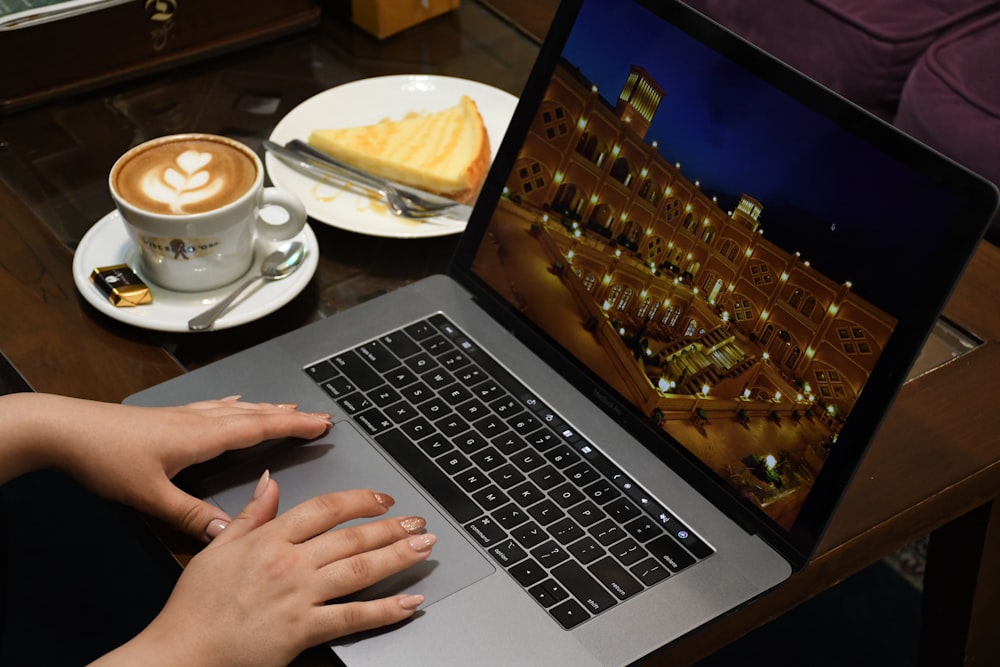 person using macbook pro on table