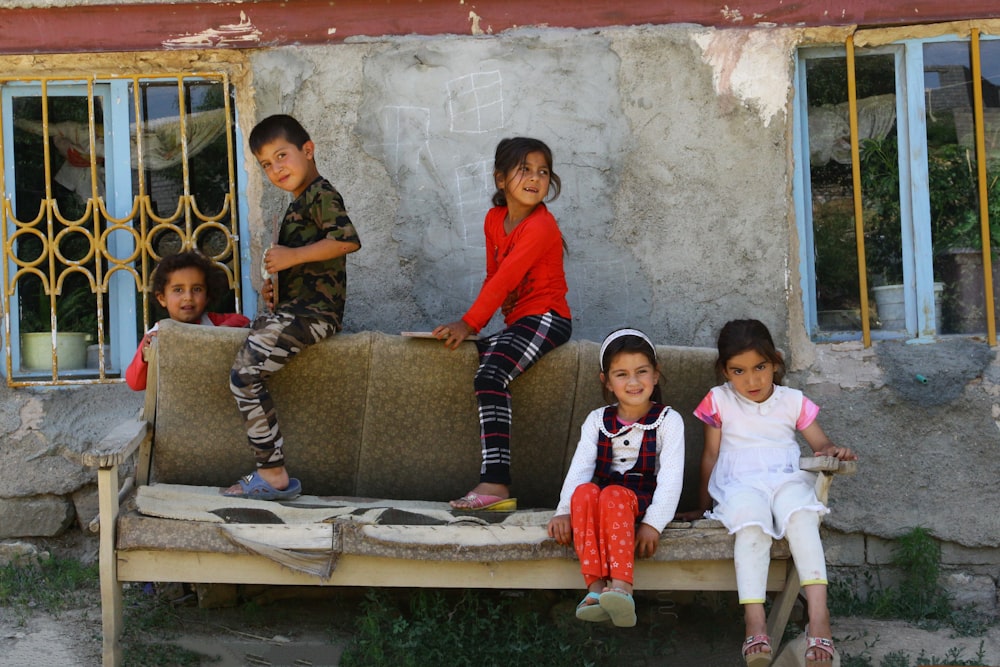 3 children sitting on brown couch