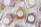 Several handmade soaps, each wrapped in paper and labeled 'Eden Crafted,' are arranged on a light fabric background. The soaps are in different colors, including shades of pink, beige, and brown. Each soap bar carries a round label with a simple botanical design and text indicating they are 100% handcrafted and locally made.