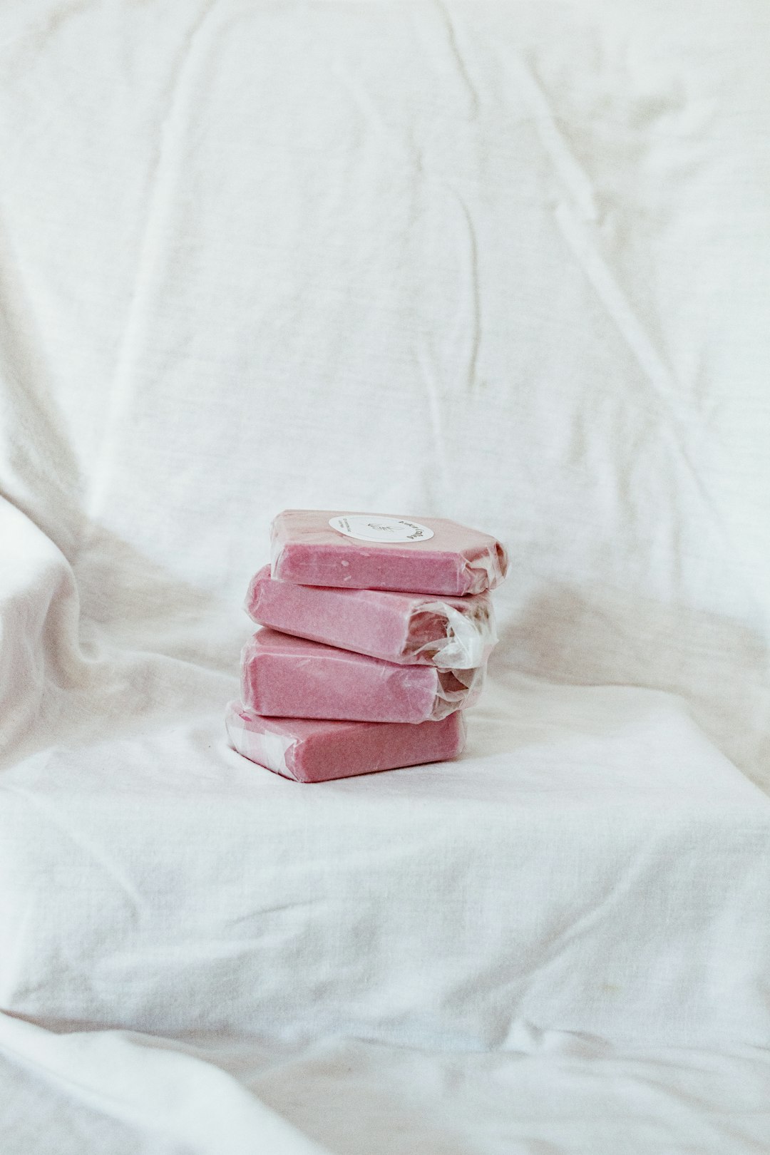 pink and white plastic container on white textile
