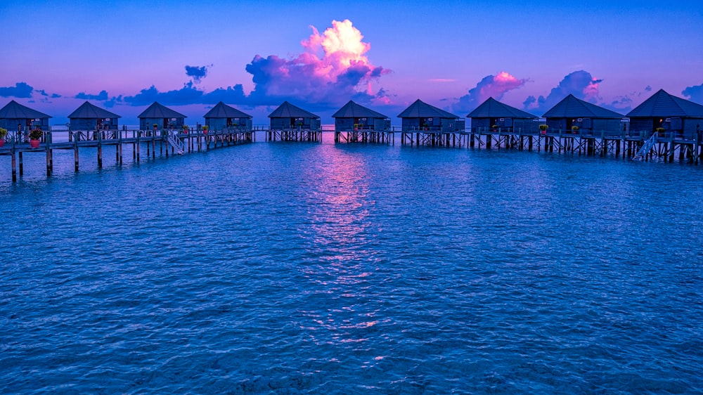 blue wooden house on sea under blue sky during daytime