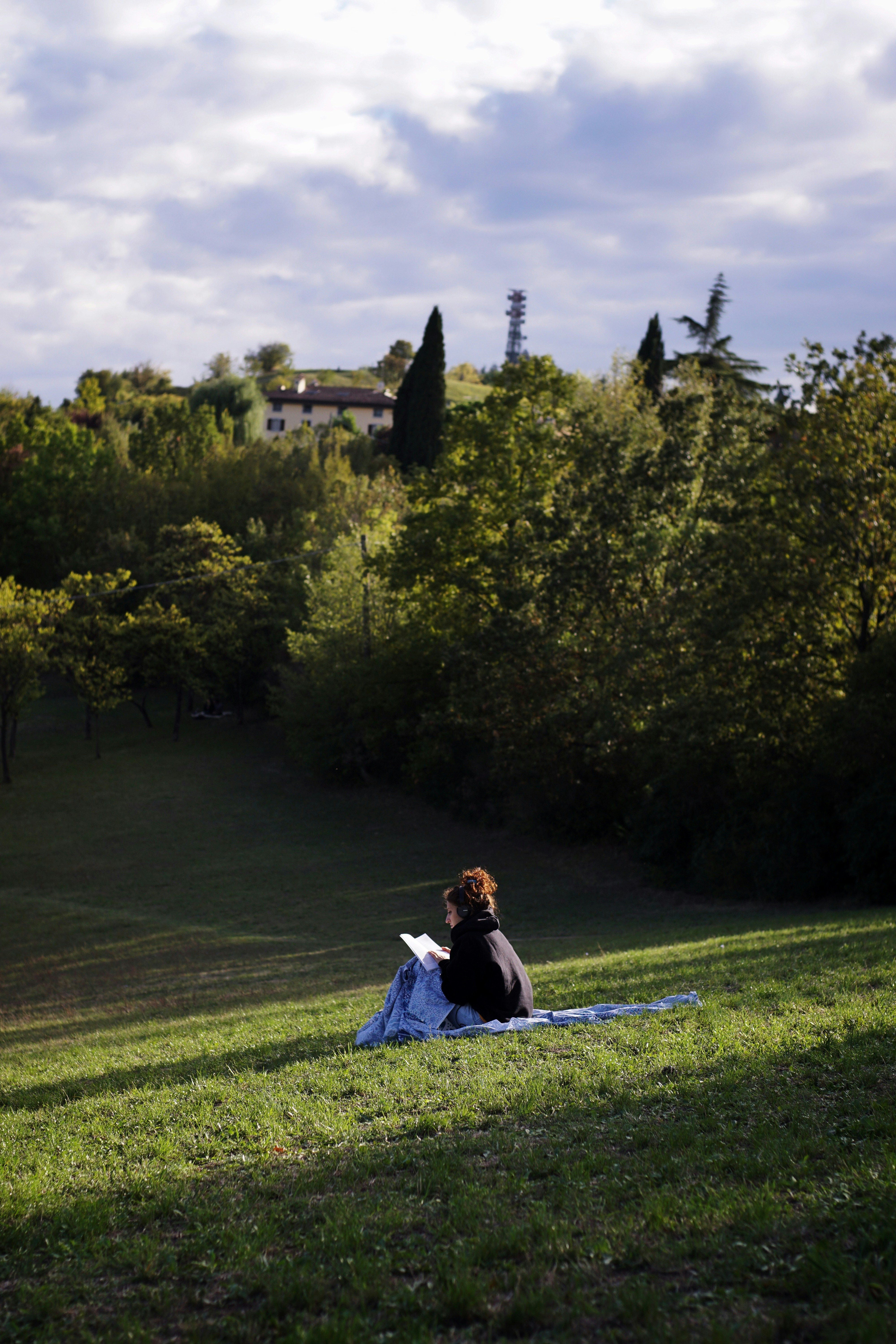 Donna che legge un libro in un parco