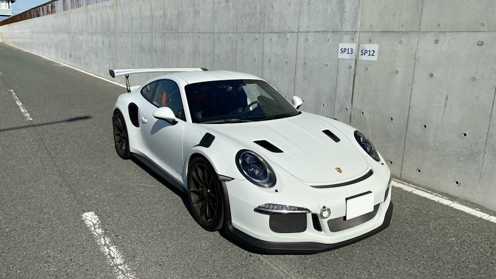 white porsche 911 parked on gray pavement