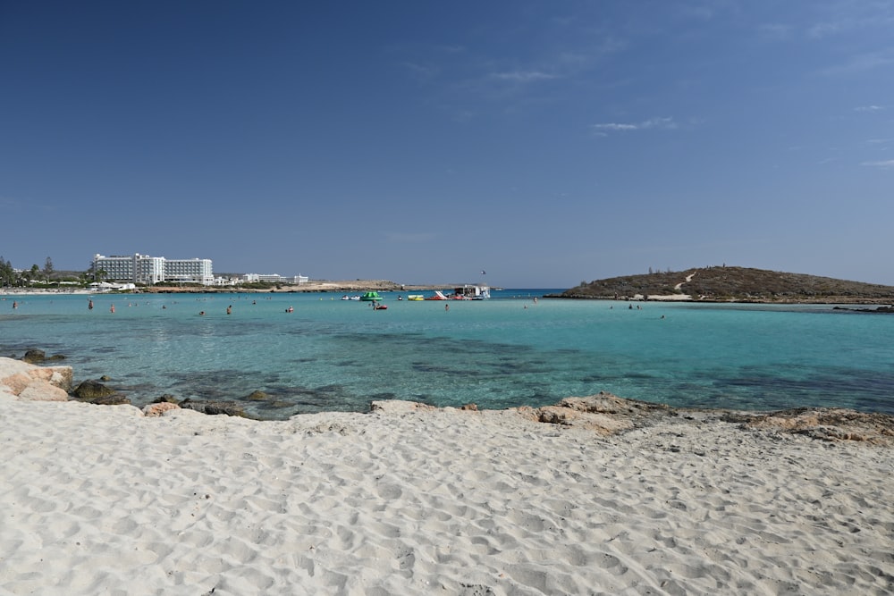 Plage de sable blanc avec mer bleue sous ciel bleu pendant la journée