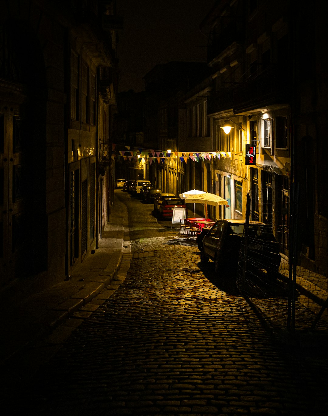 black motorcycle parked beside the road during night time