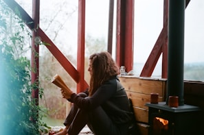 woman in black jacket sitting on brown wooden bench