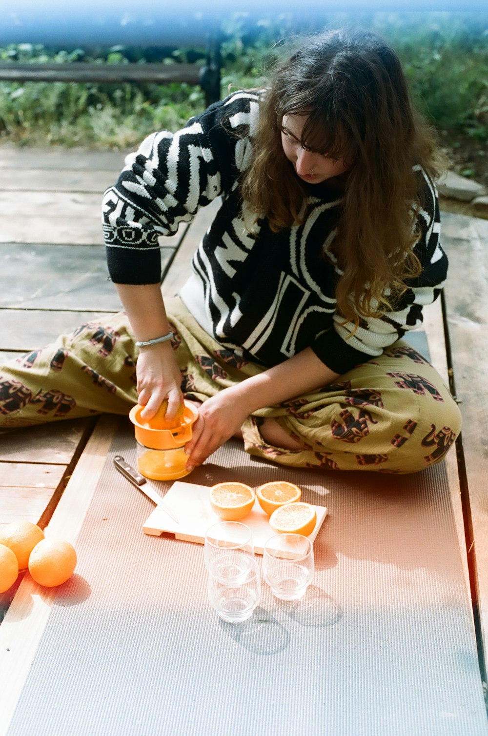 woman in black and white shirt holding orange fruit