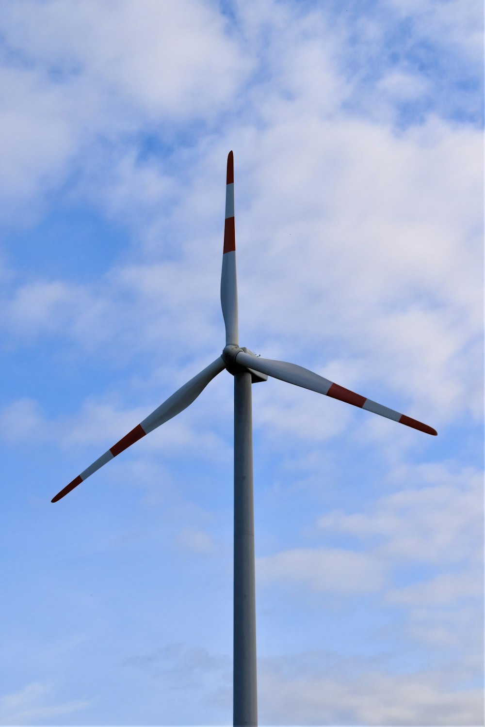 Weiße Windkraftanlage tagsüber unter blauem Himmel